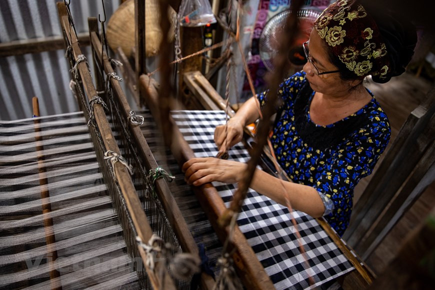In addition to specialising in making sarongs and bandanas, Mr. Mohamad also ventures into crafting new brocade patterns in myriad vibrant colours, fashioning them into diverse handbag designs to cater to the varying tastes of tourists. (Photo: Vietnam+)