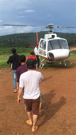 Four among 26 workers of Vietnam’s Hoang Anh Gia Lai JSC, isolated in Paksong district in Champasak province which borders Attapeu to the east, on their way to a rescued helicopter hired by the company. (Photo: VNA)