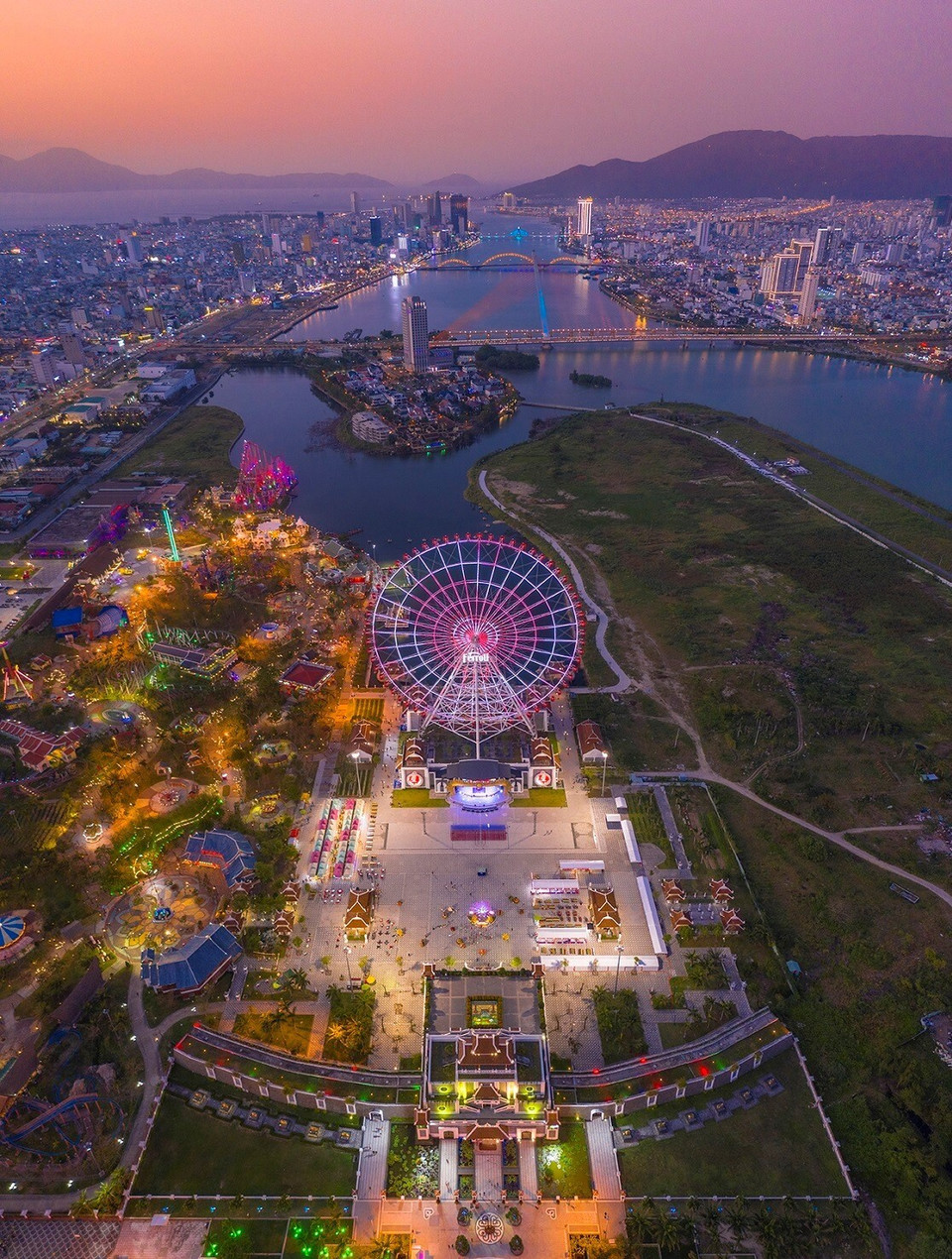 This photo captures a panoramic view of the fanciful Da Nang city in the sunset with the highlight being the sun rotation at Asia Park and the bridges spanning the Han River from afar. (Photo: Vo Van Viet)