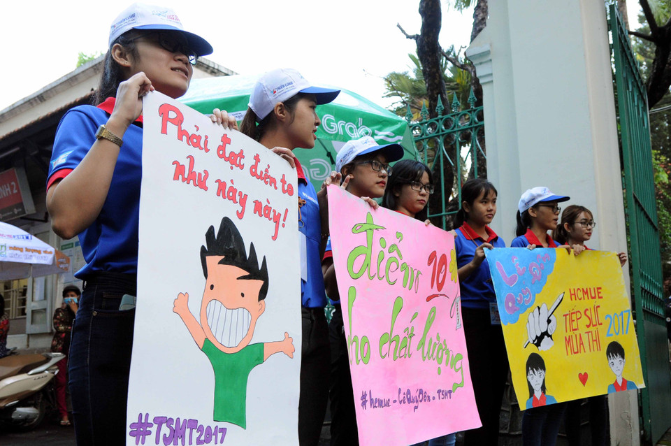 Voluntary university students show placards supporting examinees in front of the Le Quy Don High School in District 3 of Ho Chi Minh City (Photo: VNA)