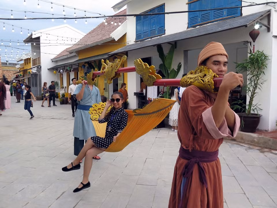 A visitor enjoys a ride on a Vietnamese-style palanquin at the theme park. (Photo: VNA)