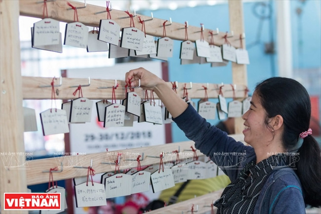 Youngsters write their wishes on Ema (wooden wishing plaque) – a unique traditional culture of the Japanese during New Year (Photo:VNA)