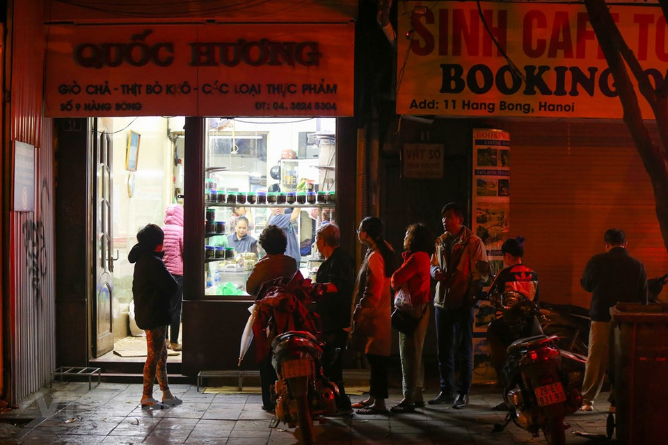 It is not a common sight: dozens of customers lined up in front of a shop in the capital city of Hanoi to buy food, as if the city had returned to the pre-market economy era. For renowned Quoc Huong shop on Hang Bong Street, Hoan Kiem district, these are simply happy days. As one of the most famous shops with generations selling pork pies, sausages and square glutinous rice cake in Hanoi, Quoc Huong shop is packed with customers when Tet comes. Tet (Lunar New Year festival) is the biggest holiday in Vietnam, and these foods are a dispensable part of the holiday (Photo: Vietnam+) 