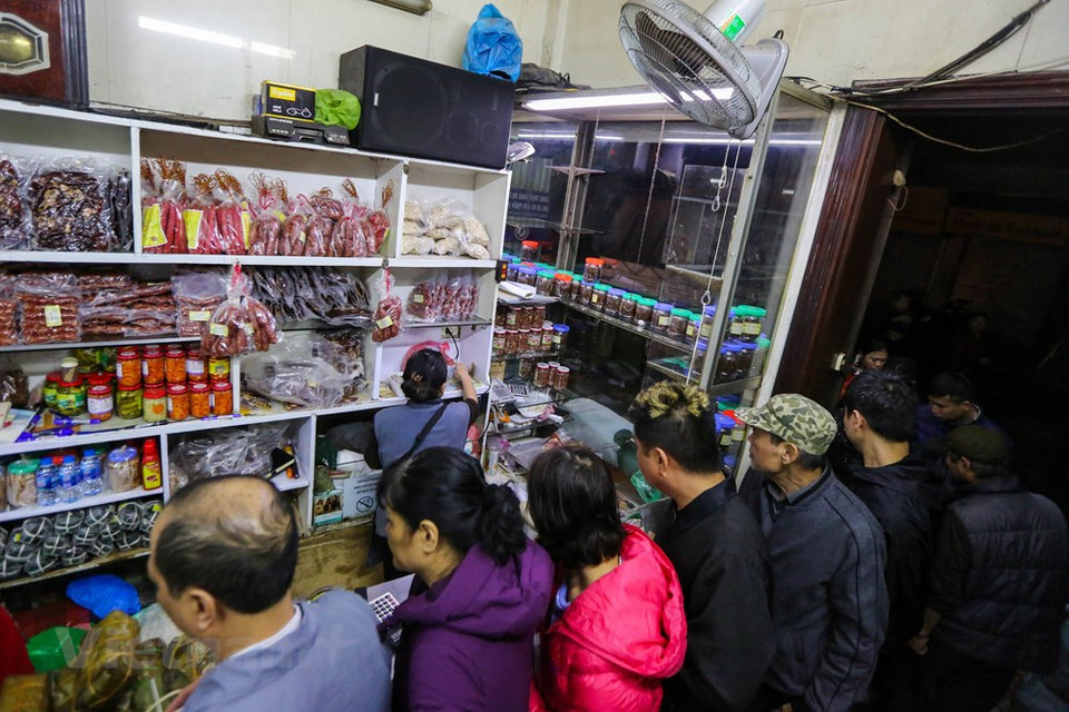People in the capital city of Hanoi often come to Quoc Huong shop to buy square glutinous rice cakes to offer to their ancestors when Tet comes. Inside the store was full of customers, but the queue is still long. Most of the customers line up and wait for their turns. The reason they defy the crowd, lining up for an hour to hold a pair of square glutinous rice cake or braised on a pork pie is because the quality and price of the product here are quite reasonable. Many customers regret because the cake was sold out, they have to move to another shop. (Photo: Vietnam+) 
