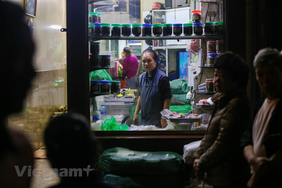Long queues of people creates an interesting view on Hang Bong street. From the 25th day of the last lunar month onwards, customers coming to Quoc Huong shop must queue in line to buy their products. Those who are in line first can go to buy cakes first. They prepare money when standing in line. It seems that this has become a routine for customers here, so no one is surprised or annoyed. Therefore, even if it takes a few hours to stand in line, customers are still happy to bring home green banh chung and delicious pork pies and sausages. For Quoc Huong shop, these are simply happy days. (Photo: Vietnam+) 