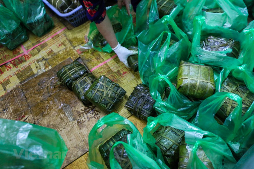 Coming here, most of shoppers buy at least two square glutinous rice cakes. According to Ms. Chan, shop owner, banh chung at her shop sells mainly to local people. Some people buy them to eat, some buy them as gifts, others buy them back home as a "specialty" gift of Hanoi. Ms. Chan recalled: ‘There were also orders from the company that placed thousands of cakes as gifts for employees and partners’. (Photo: Vietnam+) 