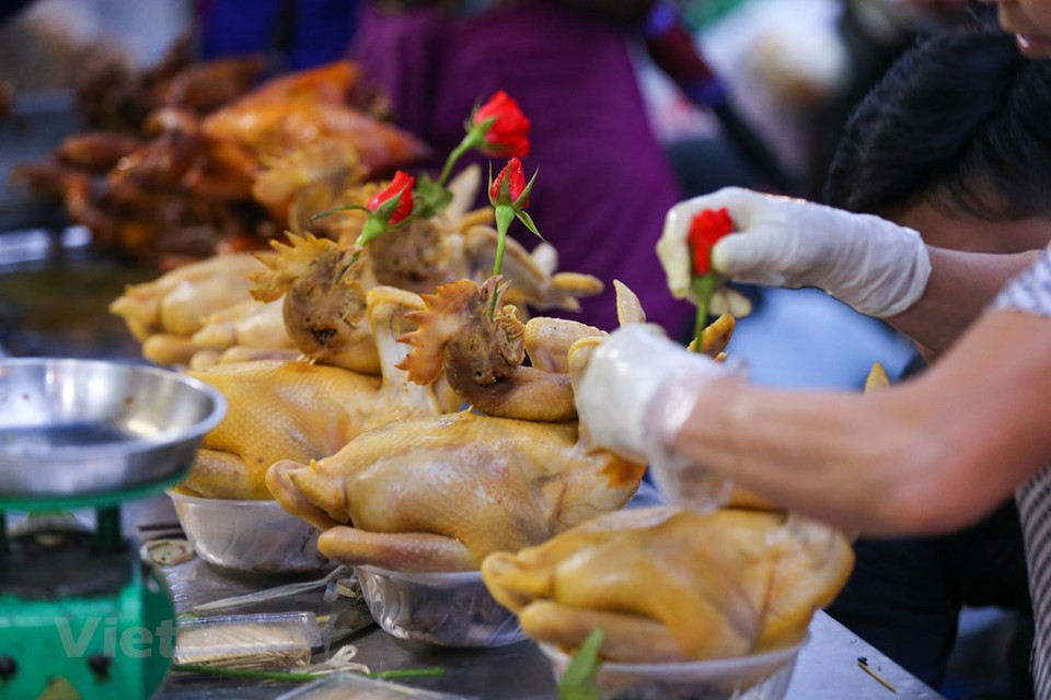 Most of the altars to worship the ancestors in Vietnam have a space for the boiled chicken – the delicious food for Tet holidays. People might put the processed whole chicken to do worshipping, but some families might decide to chop the chicken into the little pieces and display them on the plate. The food should be topped with the Vietnamese coriander and eaten with the sauce including salt, pepper, and lemon juice. The yellow boiled and skin-perfect chicken represents the good beginning of the New Year. A boiled chicken can be sold at 400,000 Vietnam dong per kilogram, which is about 17.3 USD. (Photo: Vietnam+) 
