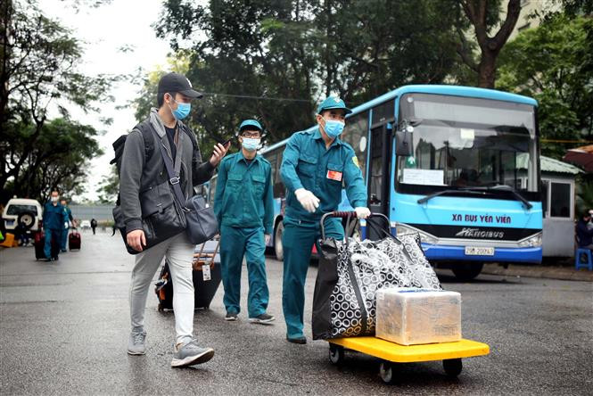 Militiamen help people finishing their quarantine time with their luggage (Photo: VNA)