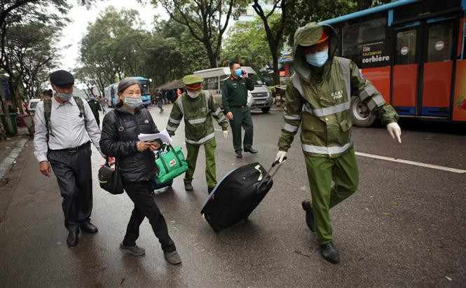 Police force helps people finishing their quarantine time with their lugguage (Photo: VNA)