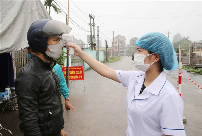A Covid-19 checkpoint in Vinh Hoa commune, Ninh Giang district is set up to check people’s temperature and write down the names of those entering the district (Photo: VNA)