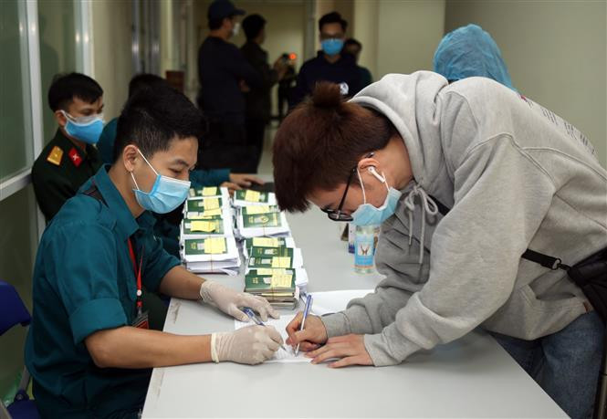 People who finish quarantine time receive passports and certificates for quarantine completion (Photo: VNA) 
