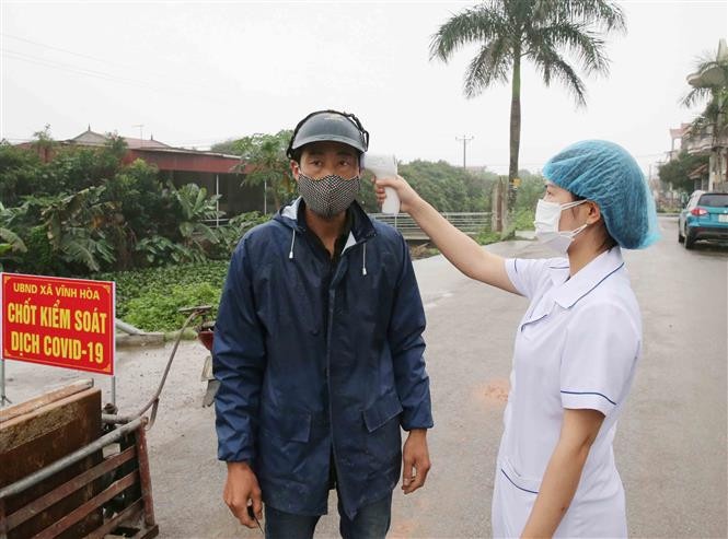 A Covid-19 checkpoint in Vinh Hoa commune, Ninh Giang district is set up to check people’s temperature and write down the names of those entering the district (Photo: VNA)
