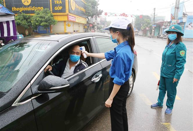 A Covid-19 checkpoint in Vinh Hoa commune, Ninh Giang district is set up to check people’s temperature and write down the names of those entering the district (Photo: VNA)
