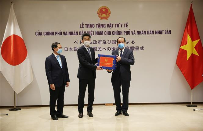 Deputy Minister of Foreign Affairs Bui Thanh Son (L), Minister and Chairman of the Office of the Government Mai Tien Dung (R) hand over the donation to Asazuma Shinichi, Envoy of the Japanese Embassy in Vietnam (Photo: VNA)