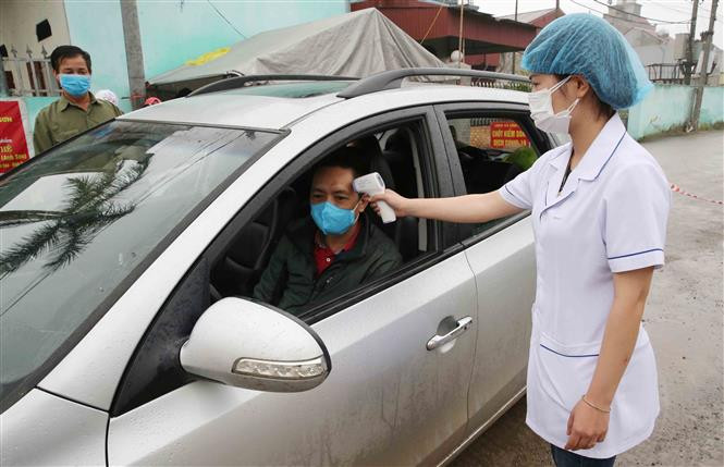 A Covid-19 checkpoint in Vinh Hoa commune, Ninh Giang district is set up to check people’s temperature and write down the names of those entering the district (Photo: VNA)
