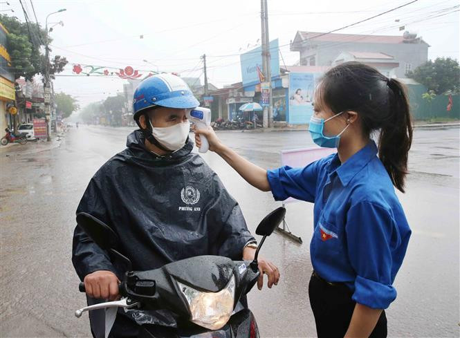 A Covid-19 checkpoint in Vinh Hoa commune, Ninh Giang district is set up to check people’s temperature and write down the names of those entering the district (Photo: VNA)