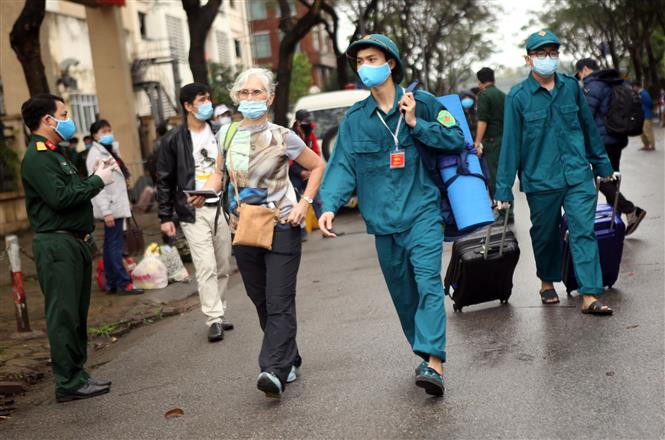 Militiamen help a foreigner with her luggage (Photo: VNA)