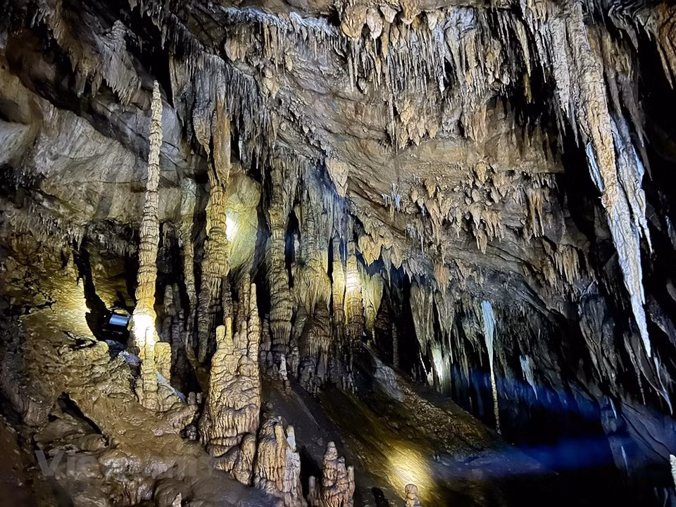 According to geologists, Nam Son cave was formed some 250 million years ago, and houses a kaleidoscope of stalactites and stalagmites in various shapes. Stalactites and stalagmites with vivid shapes seemed to hold the feet in place. Sometimes they look like the curtains of a castle, sometimes like a silk strip hanging from the cliff. There are winding stone veins that look as if they have been painstakingly installed by skilled craftsmen. There are many stalactites like silk threads on the cave walls. Located in Nam Son commune, Tan Lac district, the northern province of Hoa Binh, national relic Nam Son cave beckons adventurous travellers to conquer its pristine and mysterious beauty. (Photo: VietnamPlus)