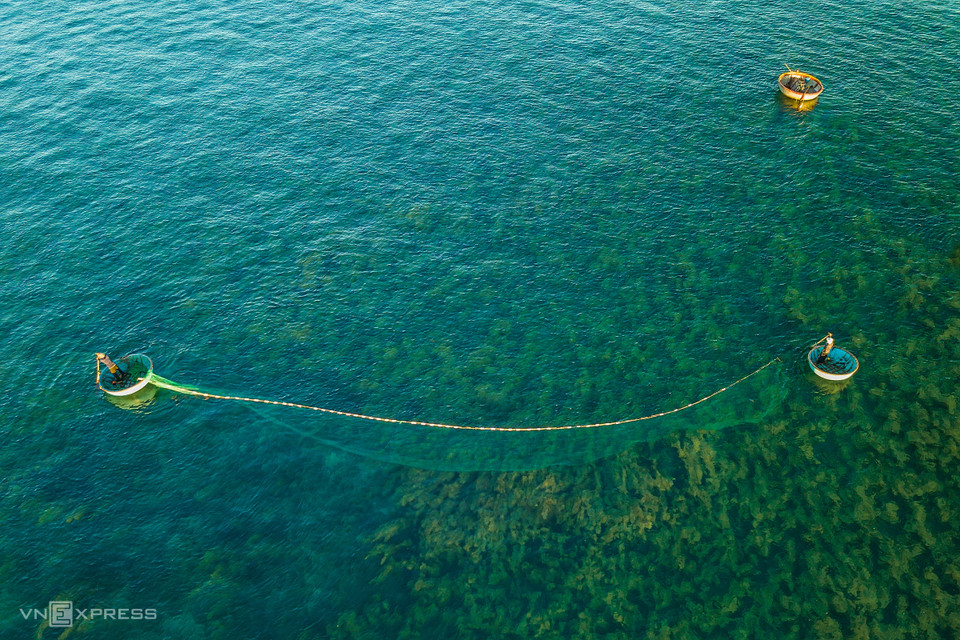 Fishing can involve one or more people. In the photo: A couple in two coracles spread their net to trap squid and other seafood, as also harvest seaweed. (Photo: vnexpress.net)