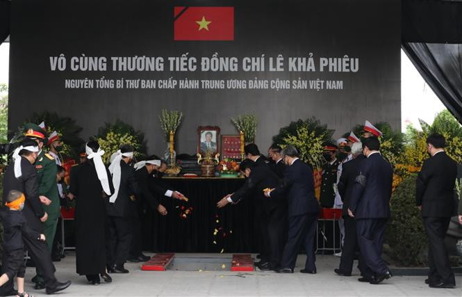 Mourners throw flowers over the casket, bidding last farewell to former Party Leader Le Kha Phieu (Photo: VNA)
