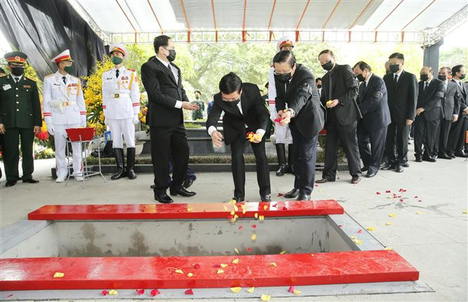 Mourners throw flowers over the casket, bidding last farewell to former Party Leader Le Kha Phieu (Photo: VNA)