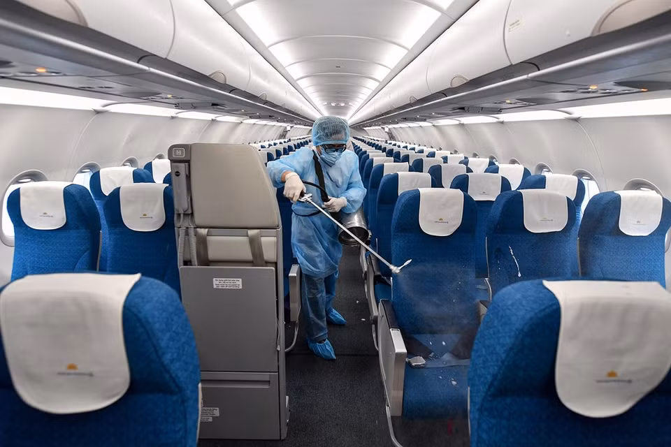  A health worker sprays disinfectants inside an airplane. According to the IATA, cleaning crew on duty must wear Personal Protective Equipment (PPE) recommended by the national public health authority. PPE requires appropriate training before use. The crew need to remove and discard gloves if the pairs become soiled or damaged, and after cleaning. They are only allowed to use cleaning agents and disinfectants that have been approved by aircraft manufacturers at recommended concentrations and contact times. They need to wash their hands with soap and water immediately after removing PPE. An alcohol-based hand sanitiser may be used as an alternative if the hands are not visibly soiled (Photo: VietnamPlus)