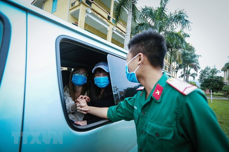 A soldier says goodbye to girls who have completed their compulsory quarantine period (Photo: VNA)
