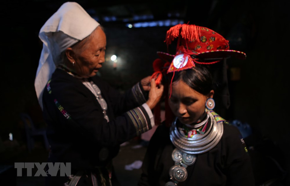 'Cap sac' ritual is divided into three levels: three lamps, seven lamps and twelve lamps, which mean the number of lamps the person passing the ritual is granted. In the photo: A Dao Tien woman dresses up for Cap sac ritual (Photo: VNA)