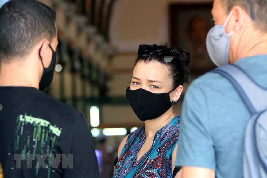 Foreign visitors wear masks in public places in Vietnam, helping prevent the spread of COVID-19 (Photo: VNA)