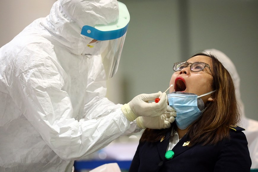 A health worker takes samples for COVID-19 testing at Noi Bai International Airport in Hanoi (Photo: VNA)