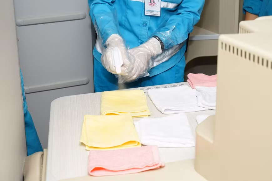 Hygiene staff uses Netbiokem DSAM, a specialized disinfectant, to clean items and interior surfaces on aircrafts (Photo: Vietnam+)
