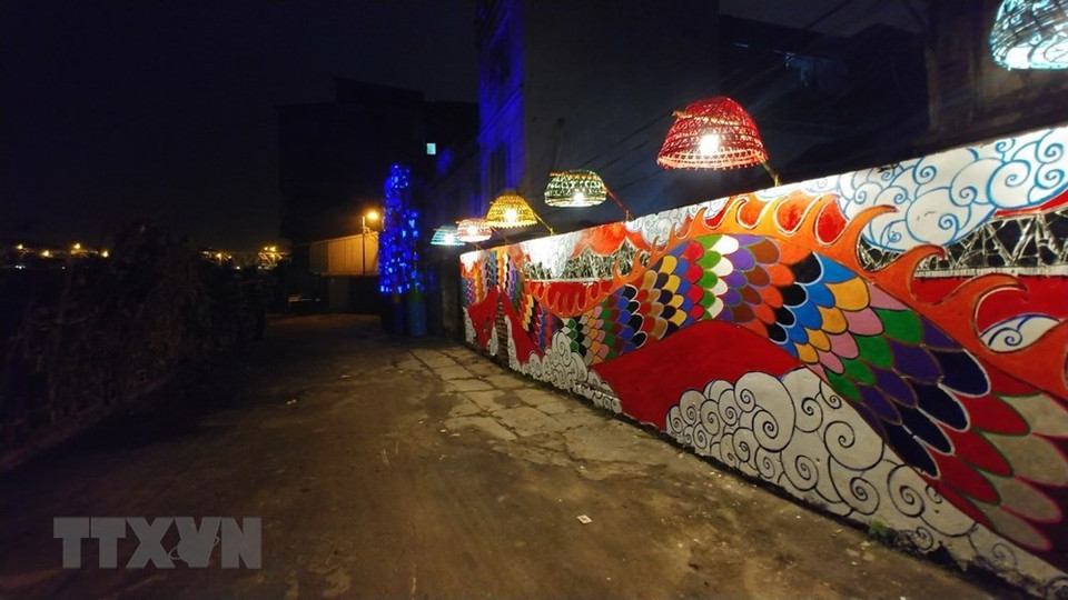 Local and international artists adorn the 200-meter-long Red River wall cutting through Phuc Tan ward, Hoan Kiem district, with various unique designs (Photo: VNA)