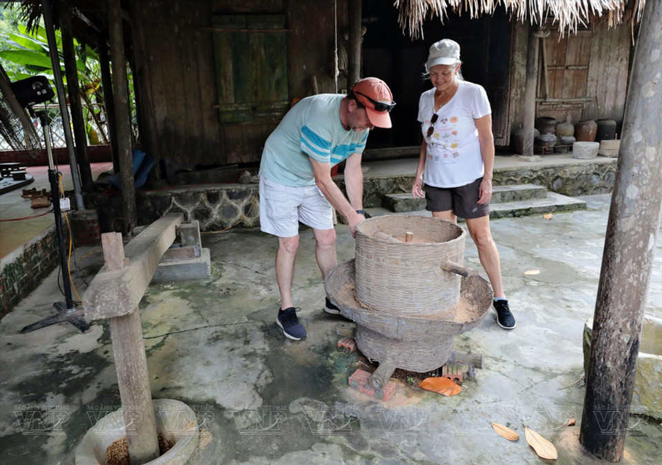 Visitors exploring a traditional rice mill. (Photo: VNP/VNA)