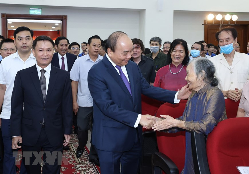 Prime Minister Nguyen Xuan Phuc greets retired staff of Vietnam News Agency (Photo: VNA)