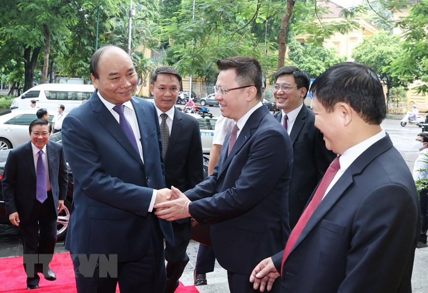 Deputy General Director of Vietnam News Agency Le Quoc Minh greets Prime Minister Nguyen Xuan Phuc when he arrives at the ceremony to mark the 75th founding anniversary of Vietnam News Agency (September 15, 1945 - September 15, 2020) (Photo: VNA)