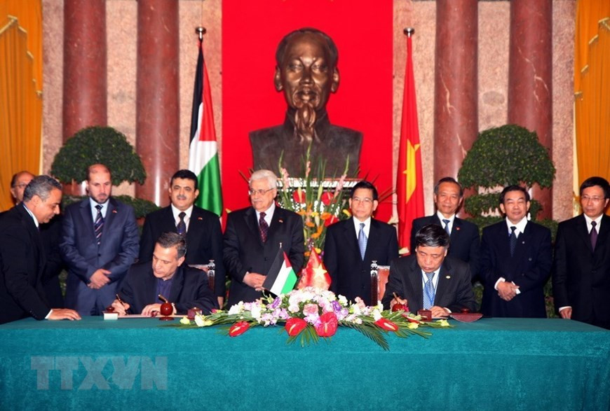 VNA General Director Tran Mai Huong and Palestinian Minister of International Cooperation Nabil G.O. Aburudainah sign a cooperation agreement between the two sides under witness of Vietnamese State President Nguyen Minh Trieu and President of Palestine Mahmoud Abbas, Hanoi, May 25, 2010 (Photo: VNA)