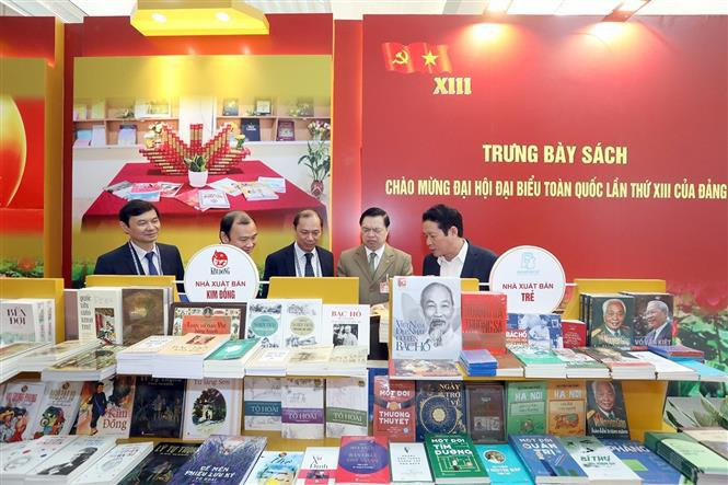 Delegates enjoy the publications in the exhibition.(Photo: VNA)