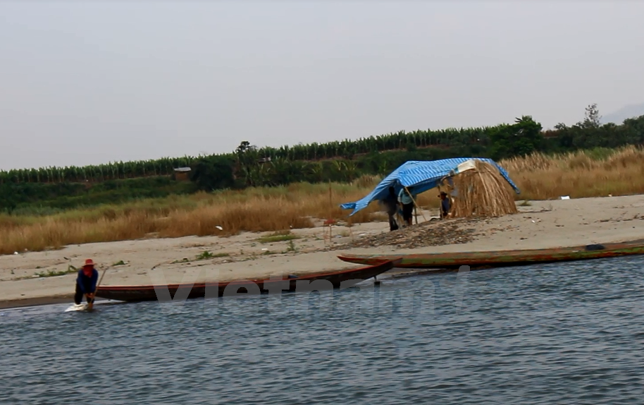 Thai people catch fish on the river. (Photo: VNA)