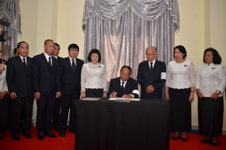 Honorary President of the Cambodian People's Party and President of the National Assembly of Cambodia Heng Samrin writes on the book of condolences at the Vietnamese Embassy in Phnom Penh. (Photo: VNA)