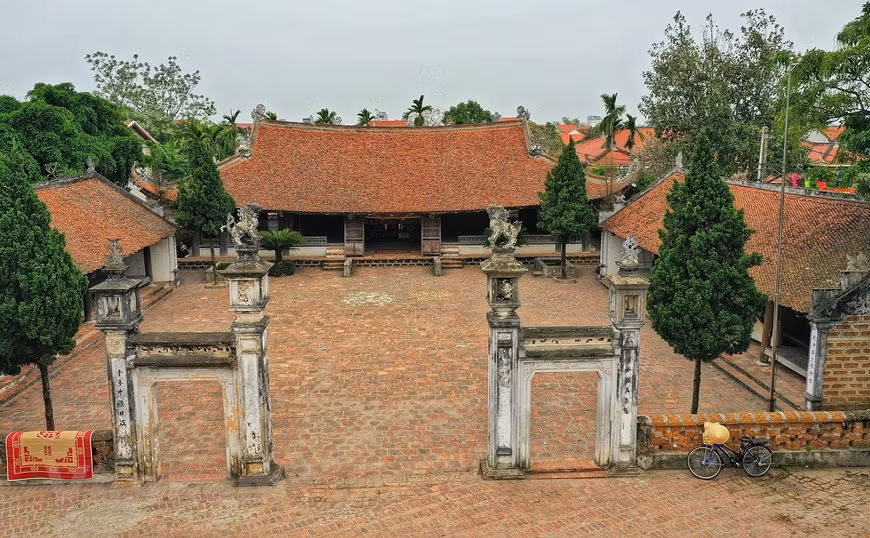 The main gate consists of four square brick pillars, two large pillars and two smaller ones. The four pillars’ tops are decorated with four sacred figures, on the top of the two large pillars there are two lions sitting at the center and on the top of two small pillars there are two vases. The pillars are decorated with 'Han' (old Chinese) characters. (Photo: Xuan Mai/Vietnam+)