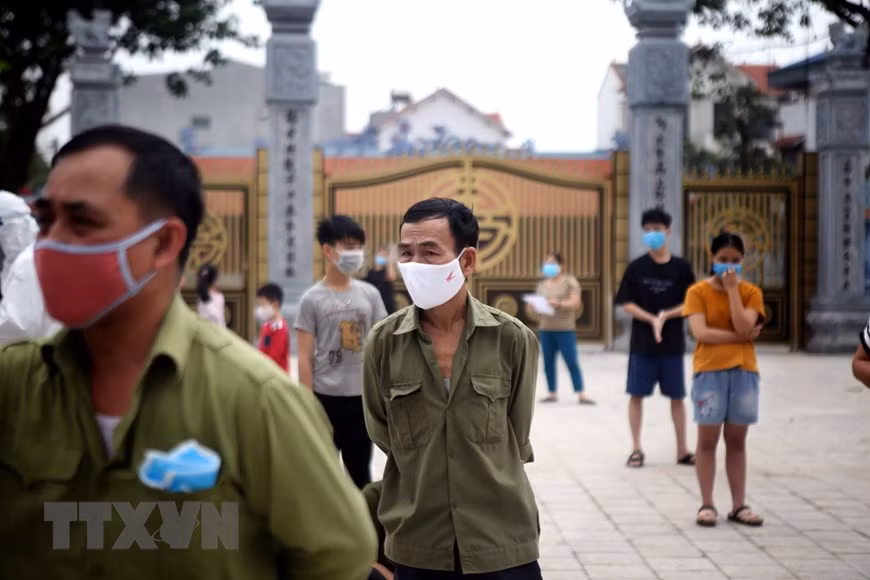 People line in queues and keep a safe distance while waiting for coronavirus test (Photo: VNA)