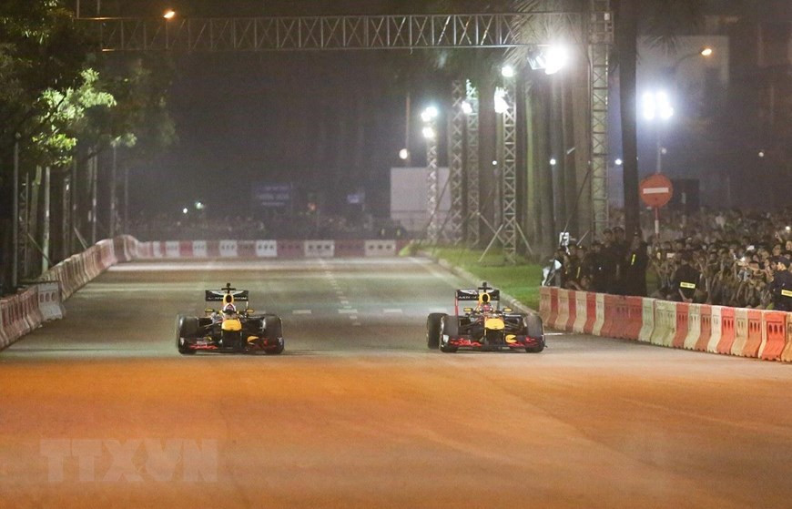 Formula One legend David Coulthard drives the Aston Martin Red Bull car and hits the streets of Hanoi, April 20 (Photo: VNA)