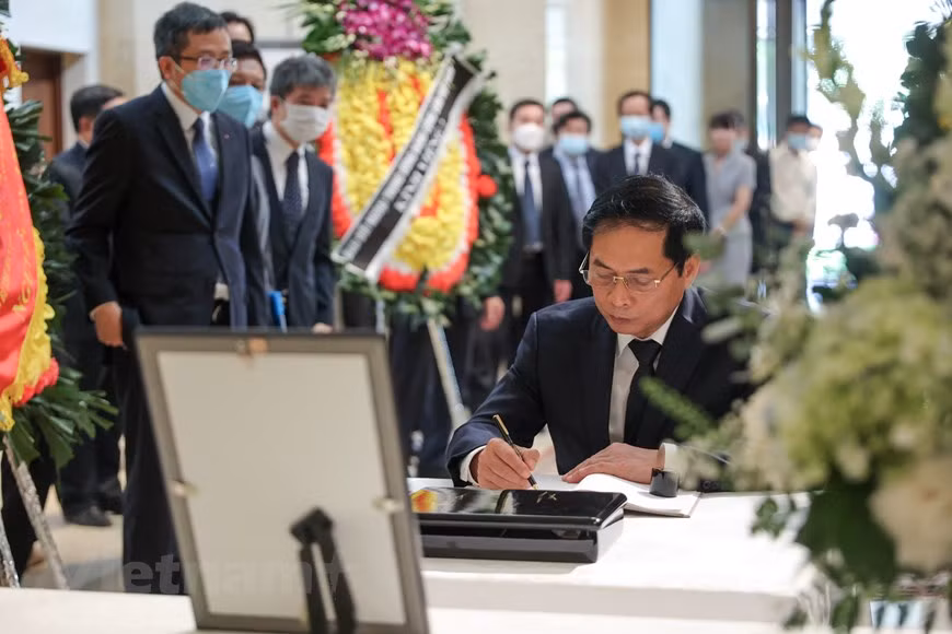 Minister of Foreign Affairs Bui Thanh Son writes in the condolence book, sharing his sorrow and sympathy with the Japanese people over the death of former Prime Minister Abe Shinzo. For the Vietnamese, former Japanese Prime Minister Shinzo Abe was always a close friend who contributed significantly to developing and elevating the friendship and close relationship between the two countries. Abe visited Vietnam four times, in November 2006, January 2013, January 2017, and November 2017 showing his strong emphasis on strengthening the extensive strategic partnership between the two countries. Furthermore, as PM, Abe prioritised promoting the provision of official development assistance (ODA) and ramping up trade-investment cooperation with Vietnam. (Photo: VietnamPlus)