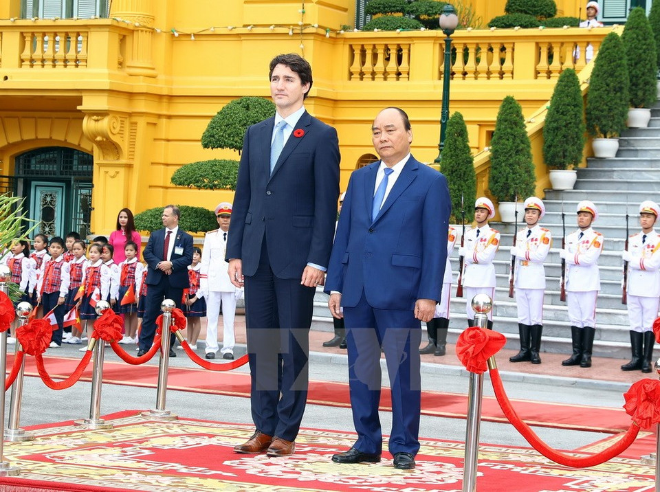 The two PMs listen to the national anthems of Canada and Vietnam (Photo: VNA)