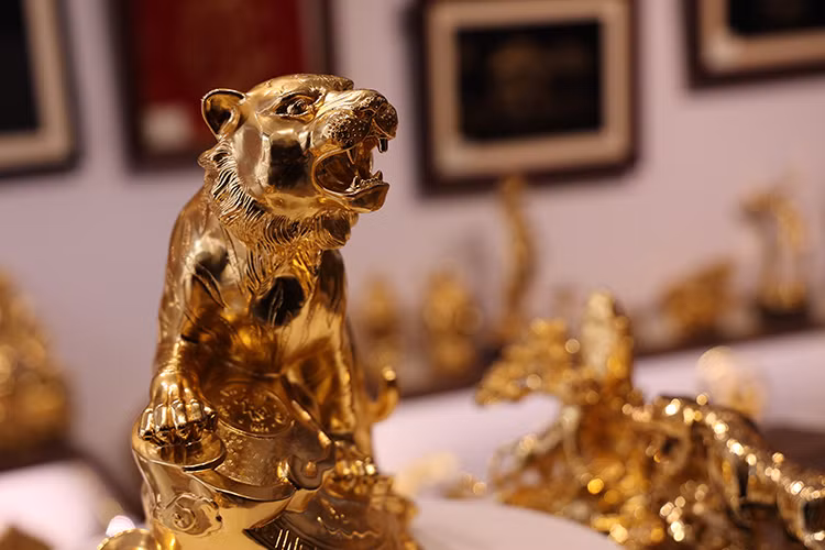 It takes days of detailed work for artisans to make a gold-plated figurine. The process requires painting, gilding, and polishing the model, which often starts with clay, then ending with a copper sculpture before being plated with the precious metal. (Photo: Tintuc/TTXVN)