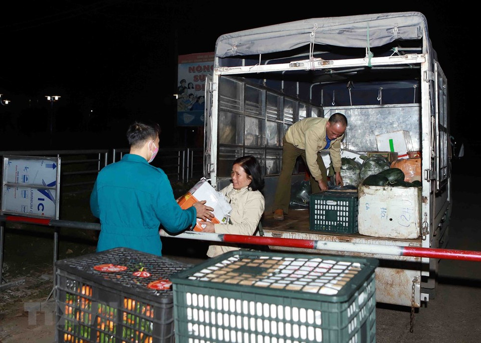 Nguyen Van Nghia in Ai Van hamlet receives fruits from outside the checkpoint (Photo: VNA)