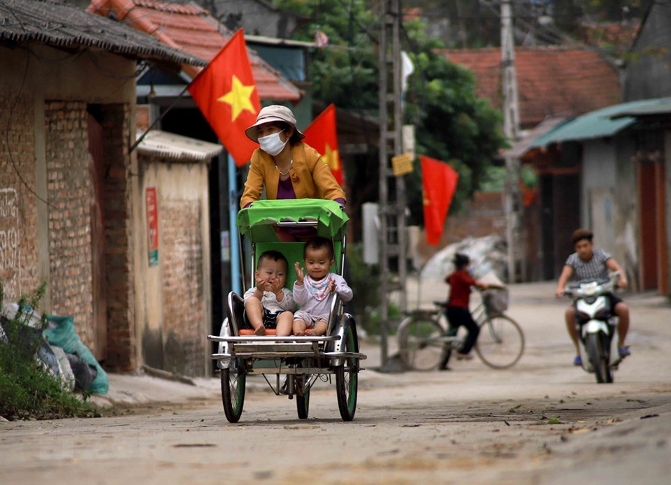 Phan Thi Hoa in An Lao hamlet takes her two grandchildren going out (Photo: VNA)