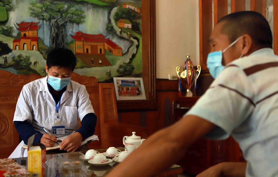 Ta Van Thanh, a staff member of Vinh Phuc provincial Centre for Disease Control, collects data on people returning home from quarantine areas in Ai Van hamlet (Photo: VNA) 