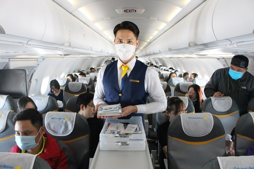 Flight attendants serve meals for passengers on the flight (Photo: Vietnam+)