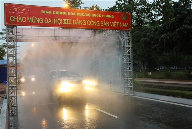 Vehicles get disinfection before entering the National Convention Centre. (Photo: VNA)